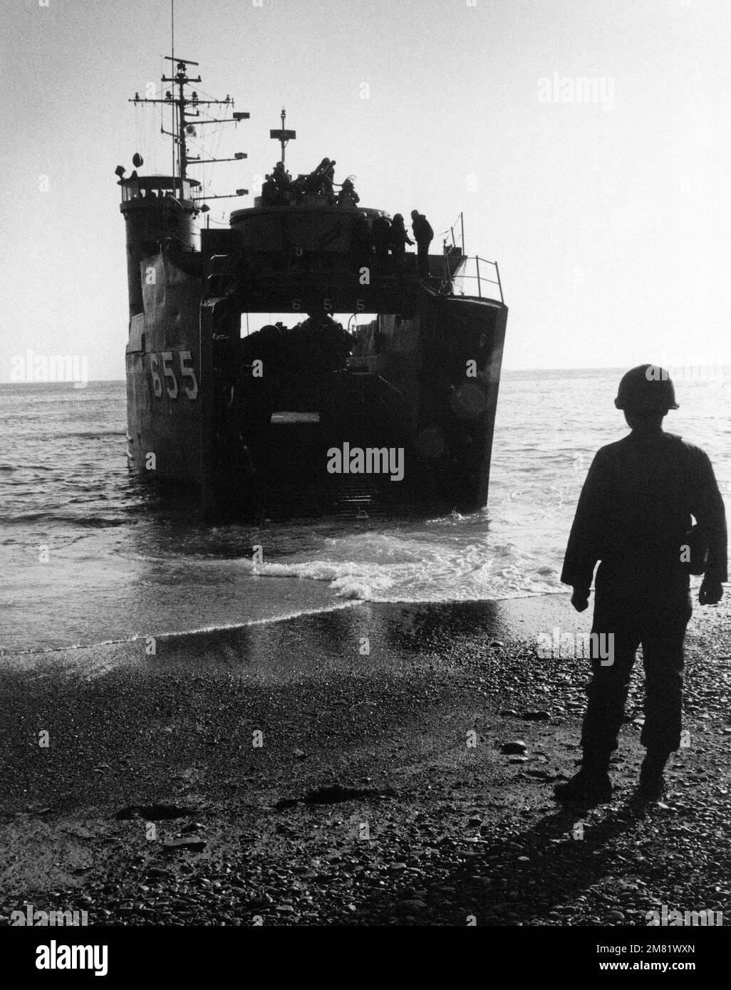 A Republic of Korea serviceman watches as a Republic of Korea tank landing ship delivers troops and cargo during an Exercise TEAM SPIRIT '84 amphibious beach landing. TEAM SPIRIT a joint/combined operation, is designed to test and improve techniques to defend the Republic of Korea Peninsula and increase combat readiness of South Korea and US armed forces. Subject Operation/Series: TEAM SPIRIT '84 Base: USS Belleau Wood (LHA 3) Country: Republic Of Korea (ROK) Stock Photo