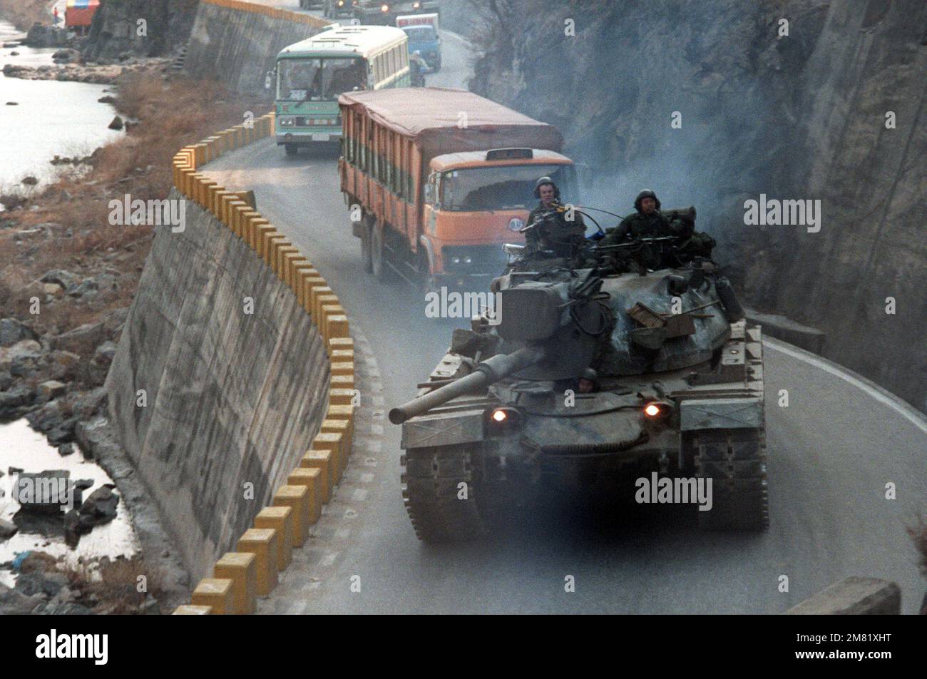 Vehicles, including an M-48A5 main battle tank, move along a mountain road during the joint South Korea/US Exercise Team Spirit '84. Subject Operation/Series: Team Spirit '84 Country: Republic Of Korea (KOR) Stock Photo