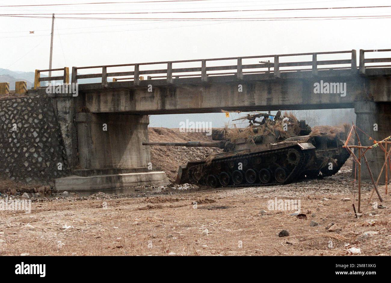An M-48A5 main battle tank, with a bulldozer blade on the front, is set up under a bridge during the joint South Korea/US Exercise Team Spirit '84. Subject Operation/Series: Team Spirit '84 Country: Republic Of Korea (KOR) Stock Photo