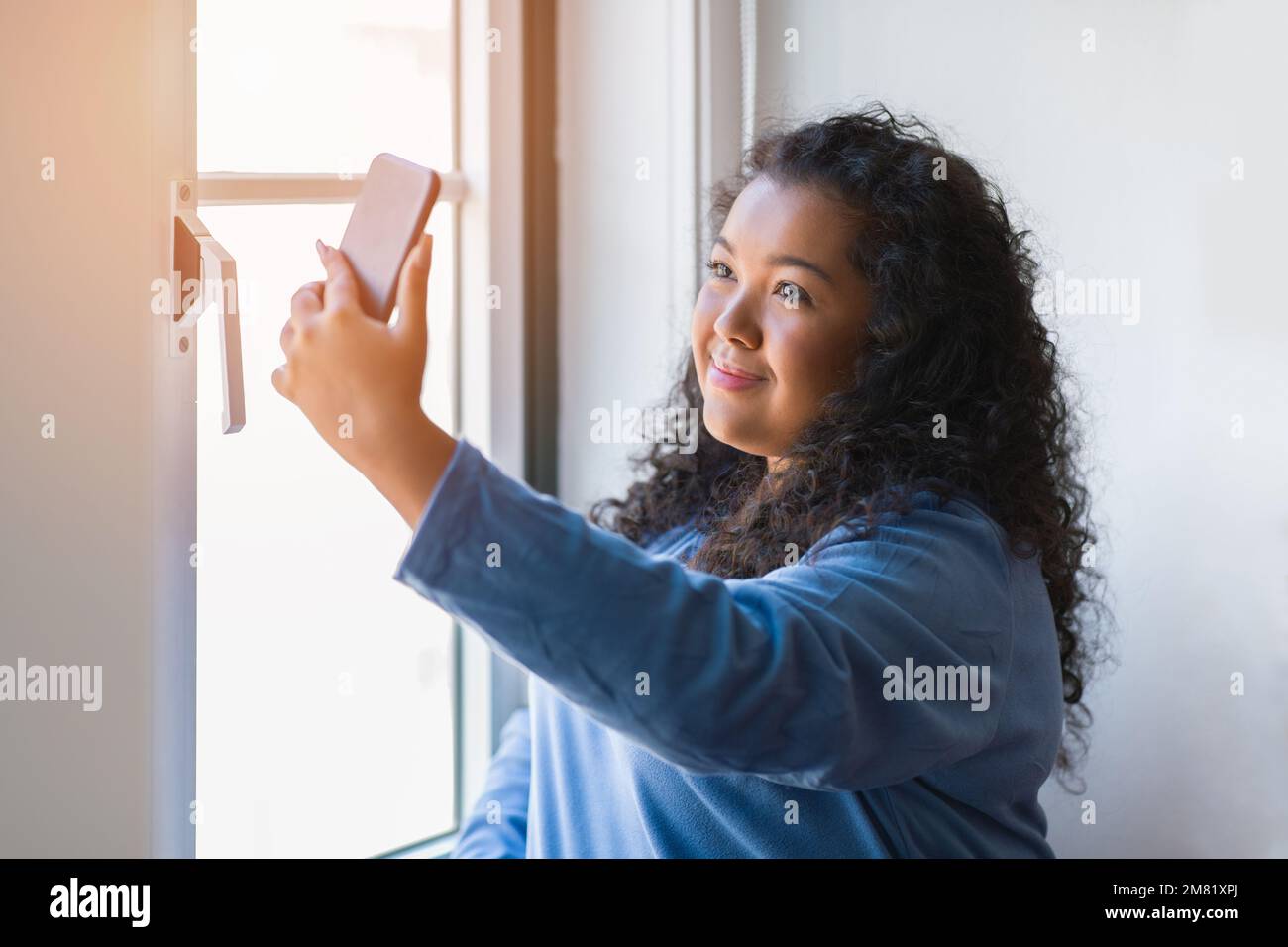 portrait beautiful chubby latin young woman taking selfies with a mobile phone indoors Stock