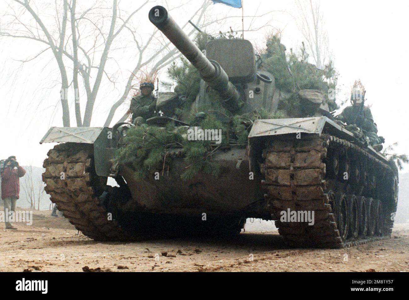 An M-48 main battle tank with Korean soldiers aboard moves down a road during the joint South Korean/US Exercise Team Spirit '84. Subject Operation/Series: Team Spirit '84 Country: Republic Of Korea (KOR) Stock Photo