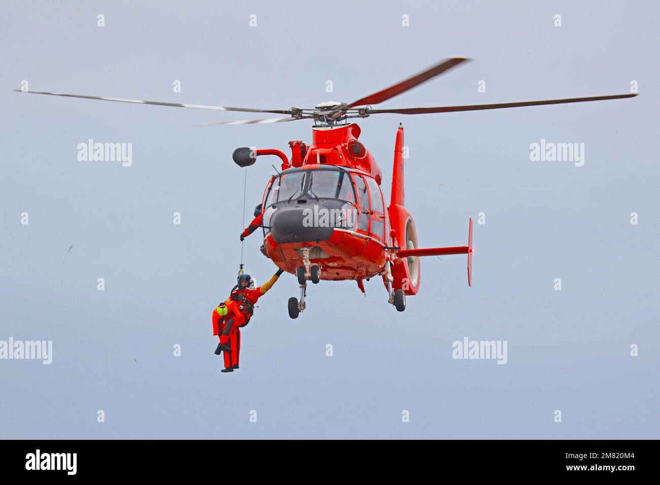 A U.S. Coast Guard Rescue Swimmer is received back onto a MH65 Dolphin helicopter by a flight