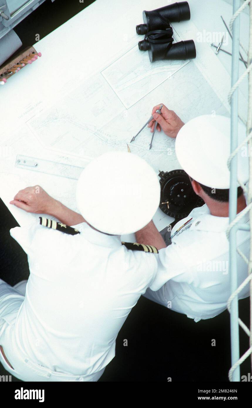 A lieutenant commander and an enlisted man use a drafting machine to