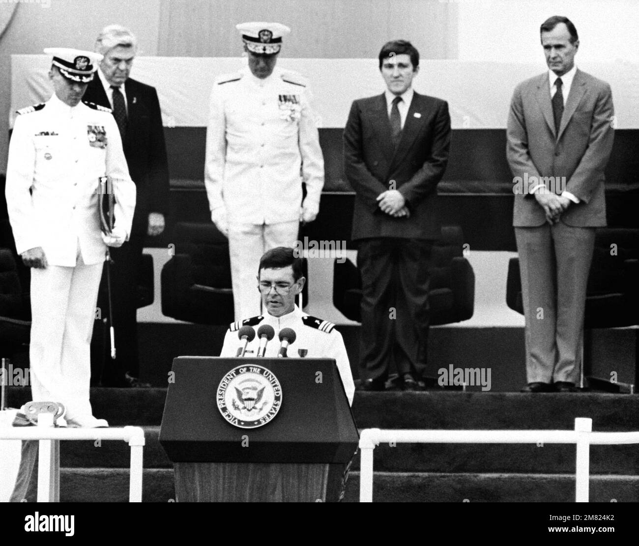 LT. CMDR. William P. Dillon, Chaplain Corps, gives the invocation during the commissioning ceremony for the USS IOWA (BB-61). Standing behind him are, right to left: Vice President George Bush, Secretary of the Navy John Lehman Jr., Adm. Wesley Mcdonald, Commander in Chief, U.S. Atlantic Fleet, and Capt. Gerald Gneckow, commanding officer, far left. Base: Pascagoula State: Mississippi (MS) Country: United States Of America (USA) Stock Photo