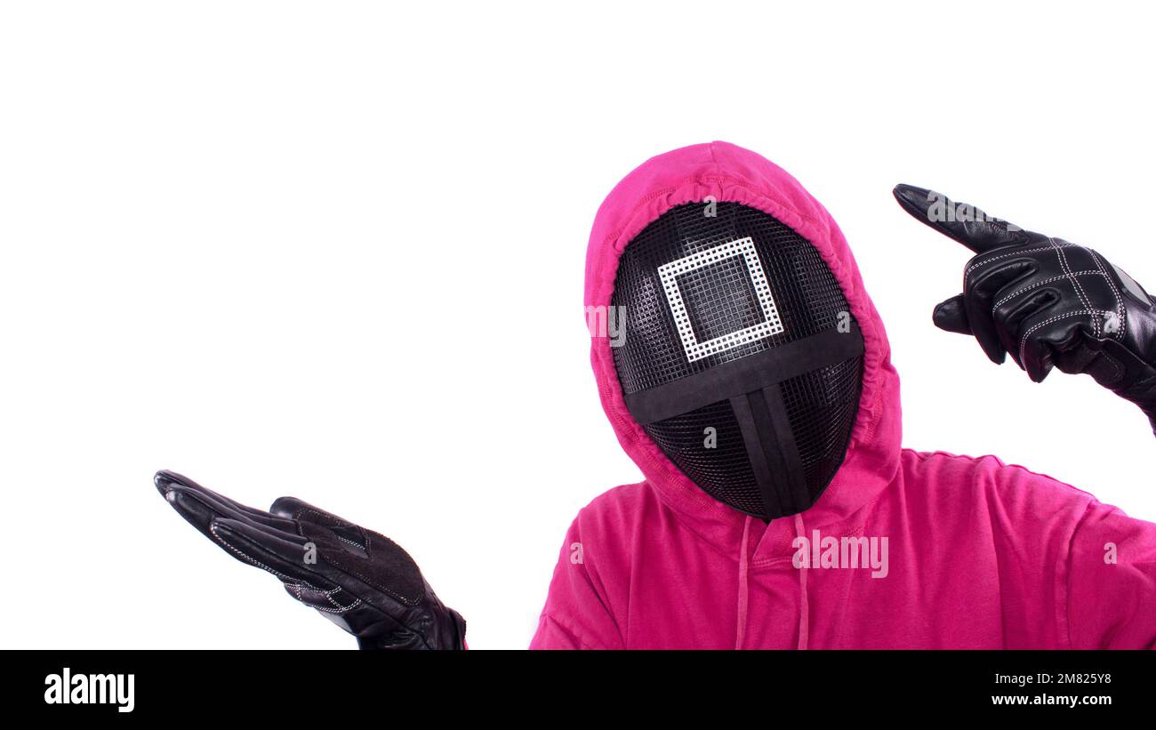 Pink Guard from Squid Game of Netflix show. Squid Game red guard holds hand up for text on white background. Space for text. South Korean tv series. G Stock Photo