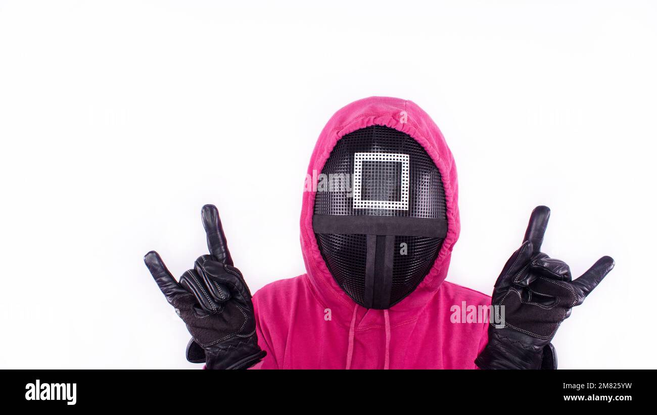 Squid Game red guard with rock horns sign hands on white background. Space for text. Pink Guard from Squid Game of new Netflix show. South Korean tv s Stock Photo