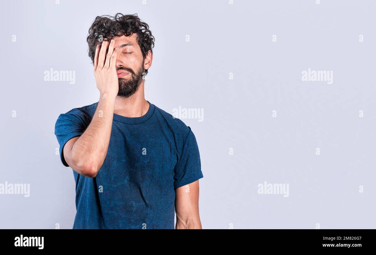 Exhausted person putting the palm of his hand on his face. Tired and exhausted man covering his face with the palm of his hand, Concept of a bored Stock Photo