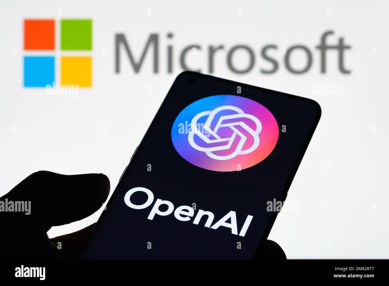 OPENAI logol seen on smartphone and laptop display with MICROSOFT logo on the background. Concept. Stafford, United Kingdom, January 11, 2023 Stock Photo