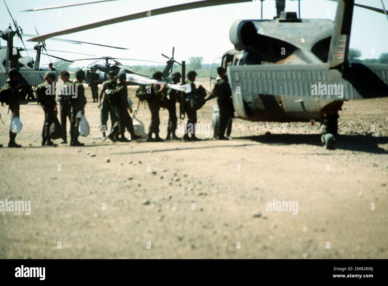 Honduran troops line up to board a UH-60 Blackhawk helicopter during ...