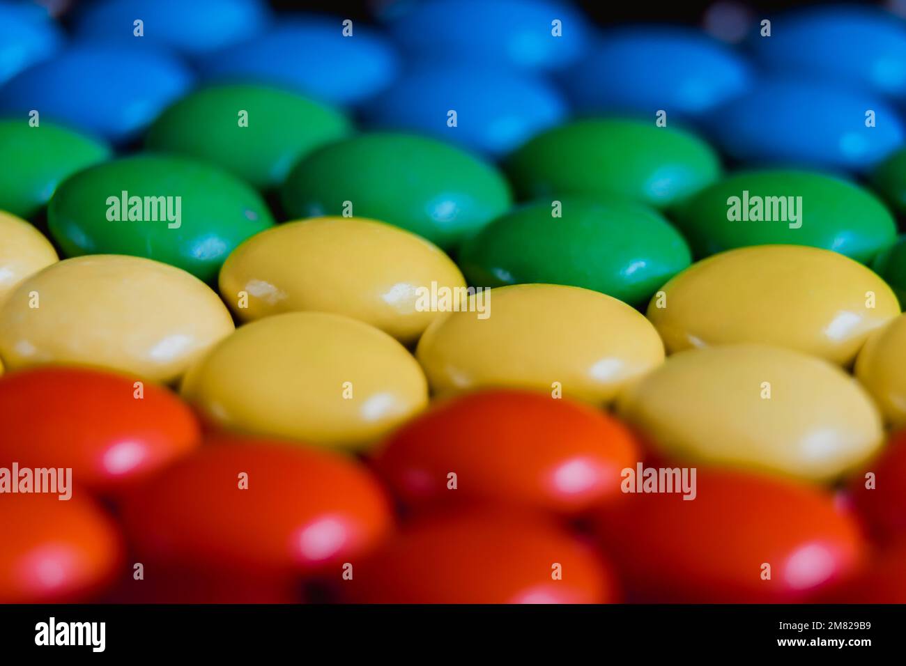 Close up view of brightly colored sweet candies laying flat. Rainbow