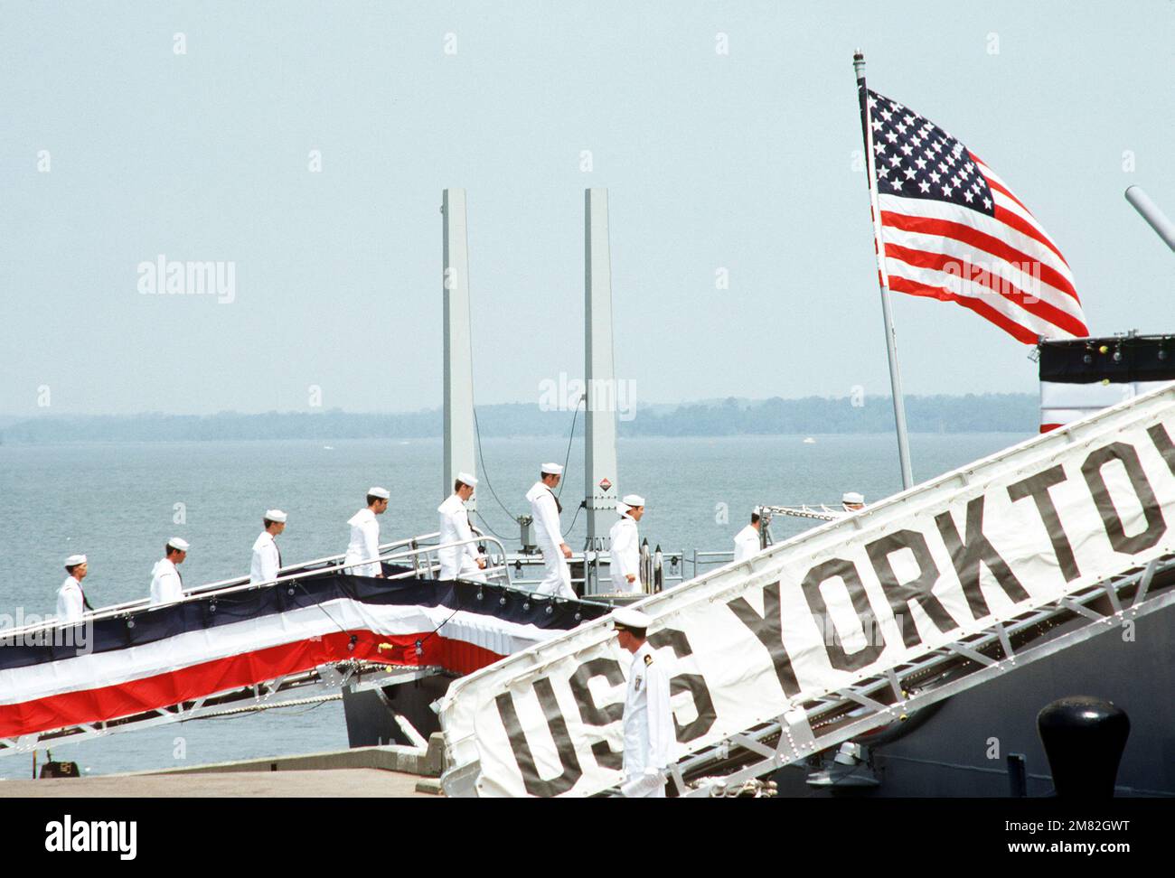 Crewmen go aboard the Aegis guided missile cruiser USS YORKTOWN (CG 48