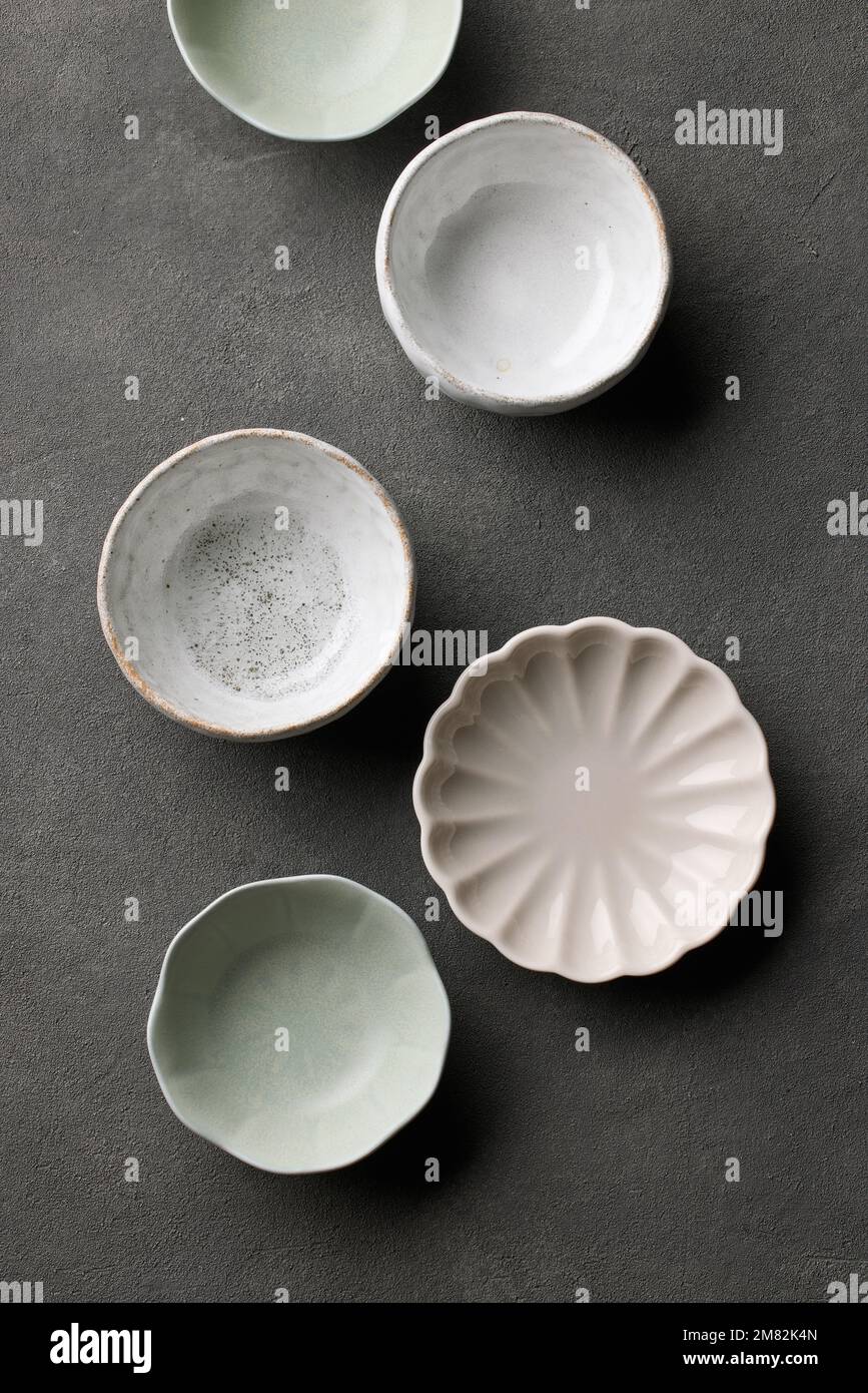 various empty bowls on dark grey background, top view Stock Photo