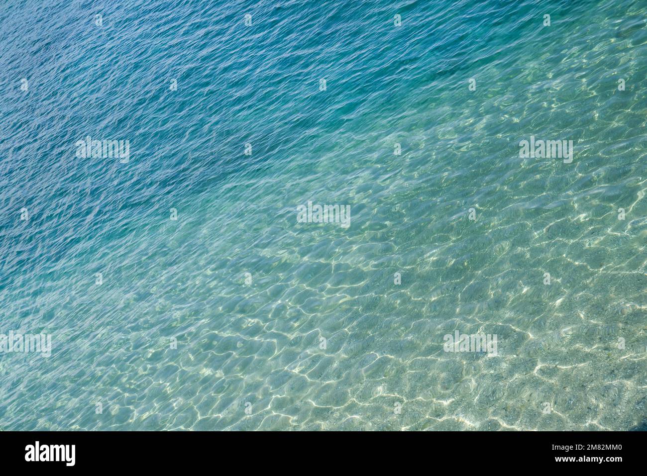 Marine water surface, sun's rays shimmer on water surface, diagonal