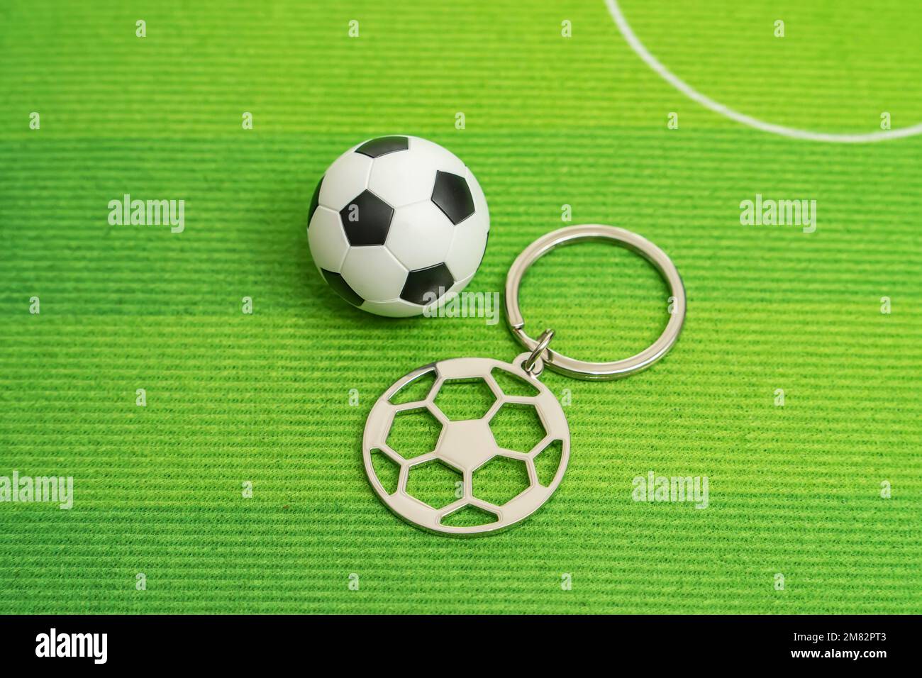 Keychain with a soccer ball on green background Stock Photo