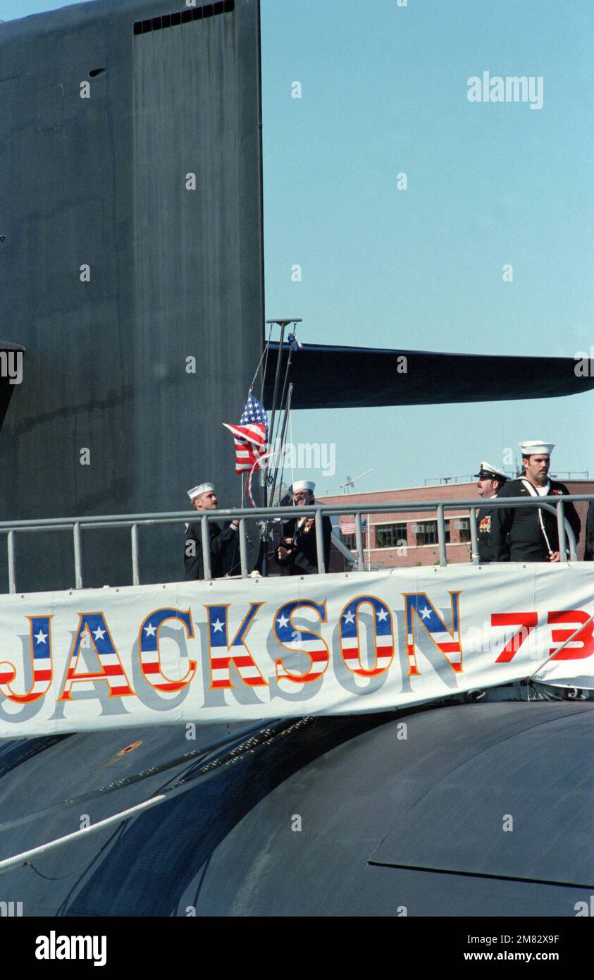 Crewman raise the ensign aboard the USS HENRY M. JACKSON (SSBN 730