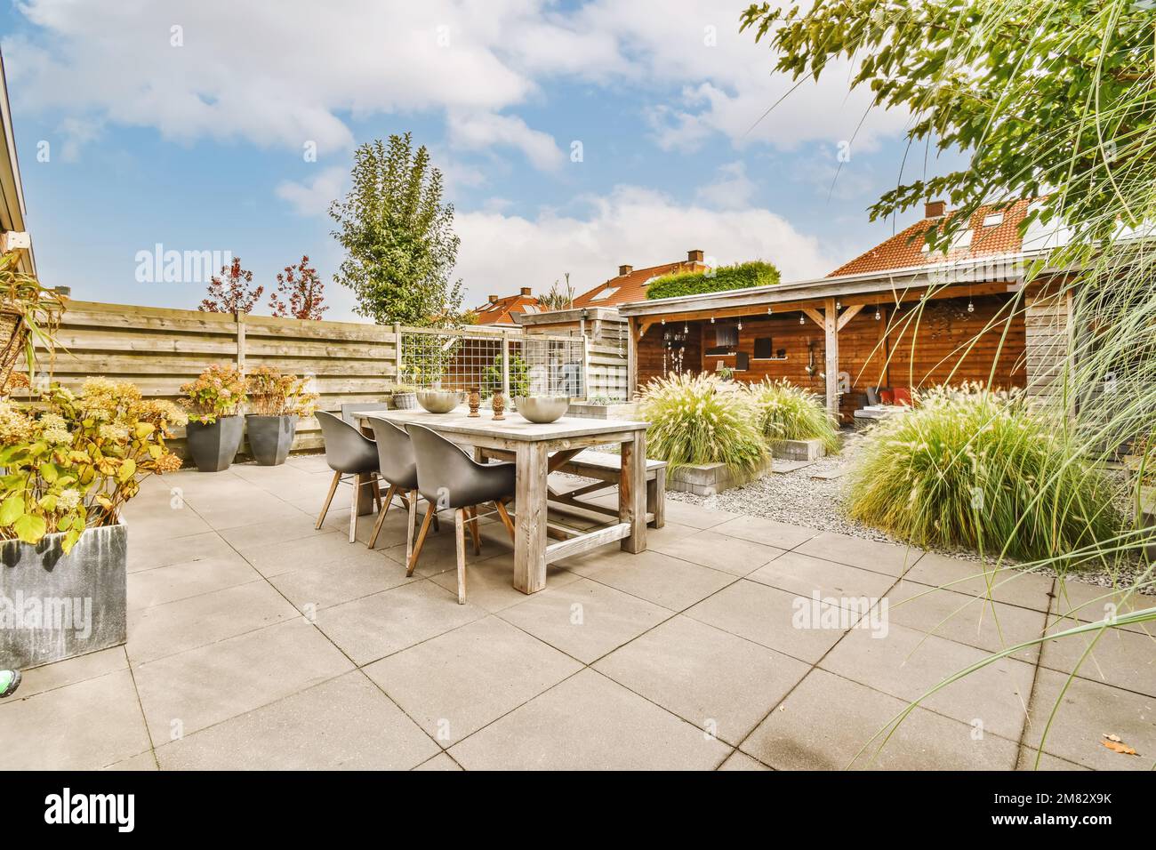 an outdoor patio with table, chairs and potted plants in the background ...