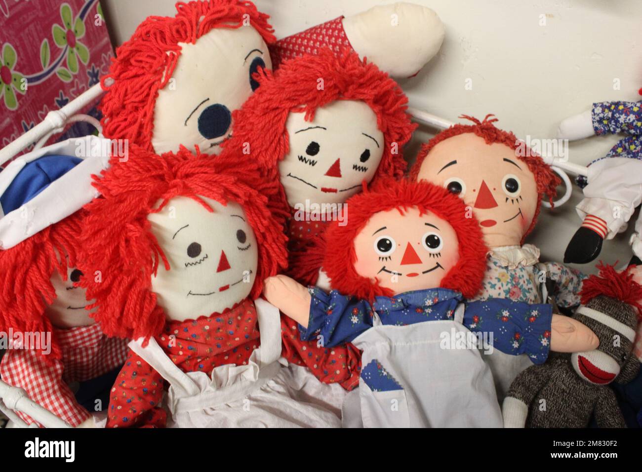 Vintage rag dolls in doll bed Stock Photo