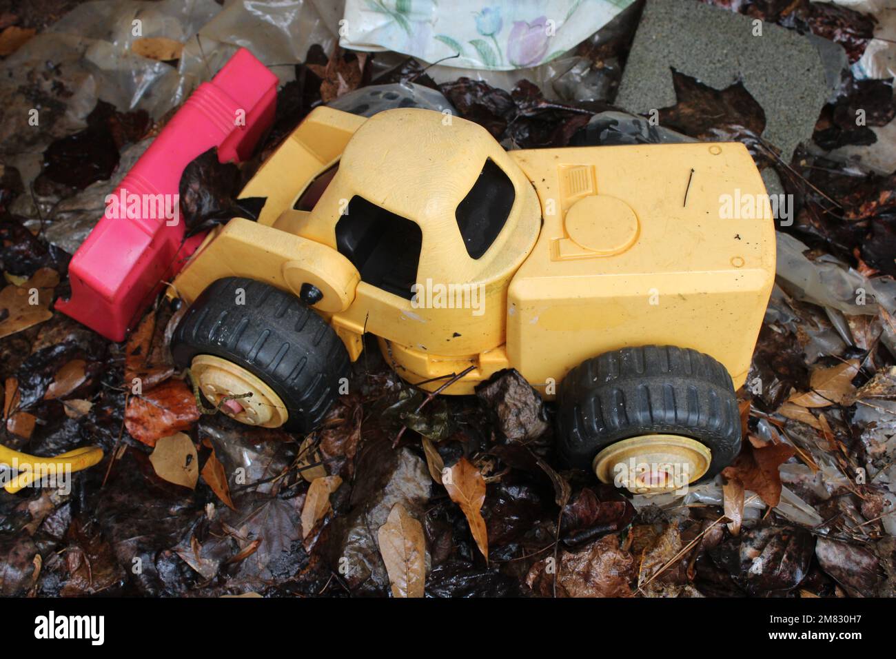 Yellow plastic bulldozer on wet ground Stock Photo
