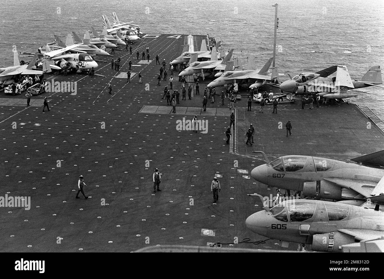 Aircraft parked on the flight deck of the aircraft carrier USS CONSTELLATION (CV 64) include S-3A Vikings, F/A-18A Hornets, EA-6B Prowlers, and an A-6E Intruder. The carrier is participating in Fleet Exercise 85. Base: USS Constellation (CV 64) Country: Pacific Ocean (POC) Stock Photo