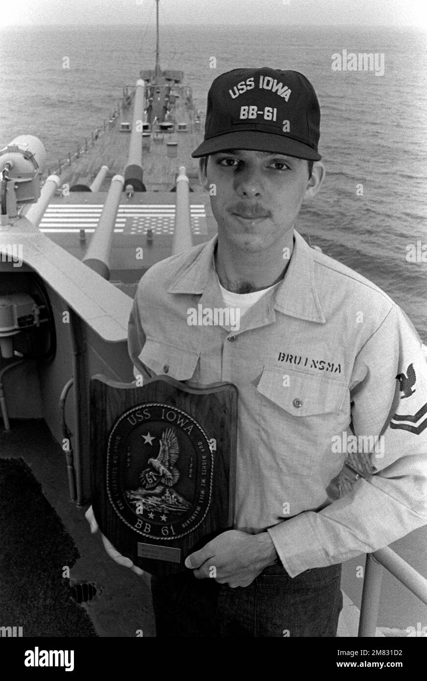 Interior Communications Electrician Second Class (IC2) Clifford Bruinsma holds a reenlistment plaque on the 05 level of the battleship USS IOWA (BB-61). Country: Atlantic Ocean (AOC) Stock Photo