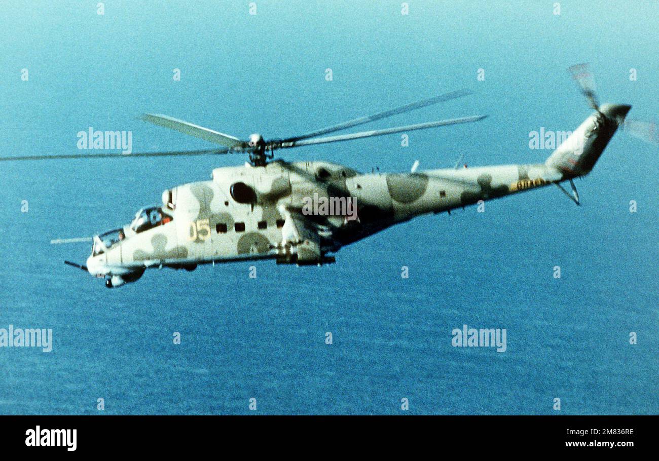 A left side view of a Soviet-made Mi-24 Hind-D assault helicopter in-flight. Country: Unknown Stock Photo