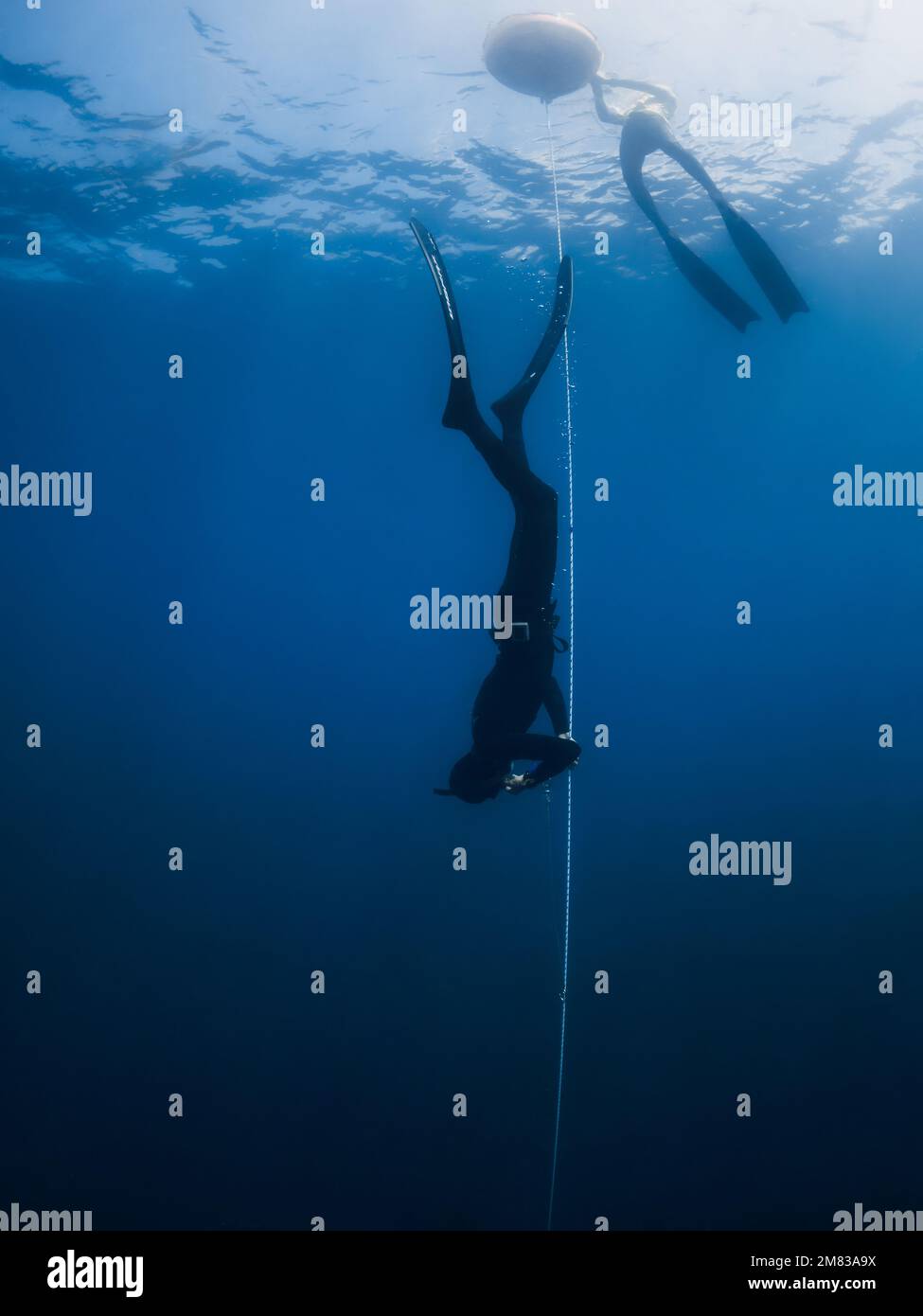 October 03, 2022. Amed, Indonesia. Men in wetsuit with fins training