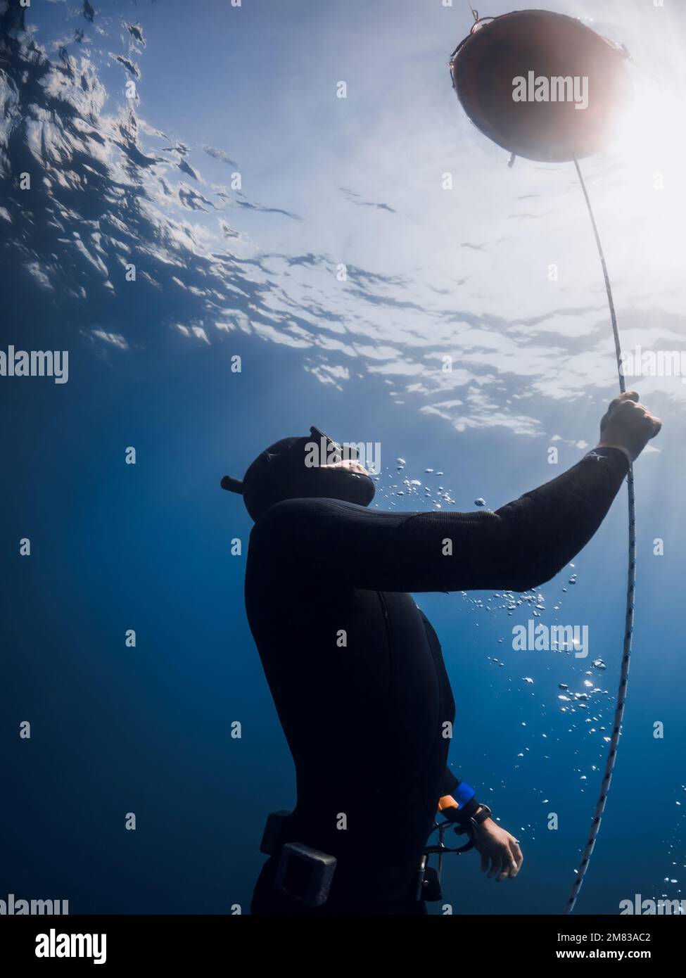 October 03, 2022. Amed, Indonesia. Men in wetsuit with fins training