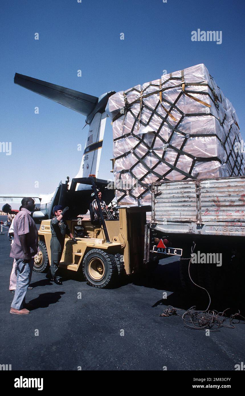 MASTER SGT. Edward Barnes, loadmaster from the 6th Military Airlift Squadron, directs the loading of one of 11 pallets of supplies onto a waiting truck during Ethiopian relief operations. The supplies will be moved to a distribution center and given to the needy. Base: Khartoum Country: Sudan (SDN) Stock Photo