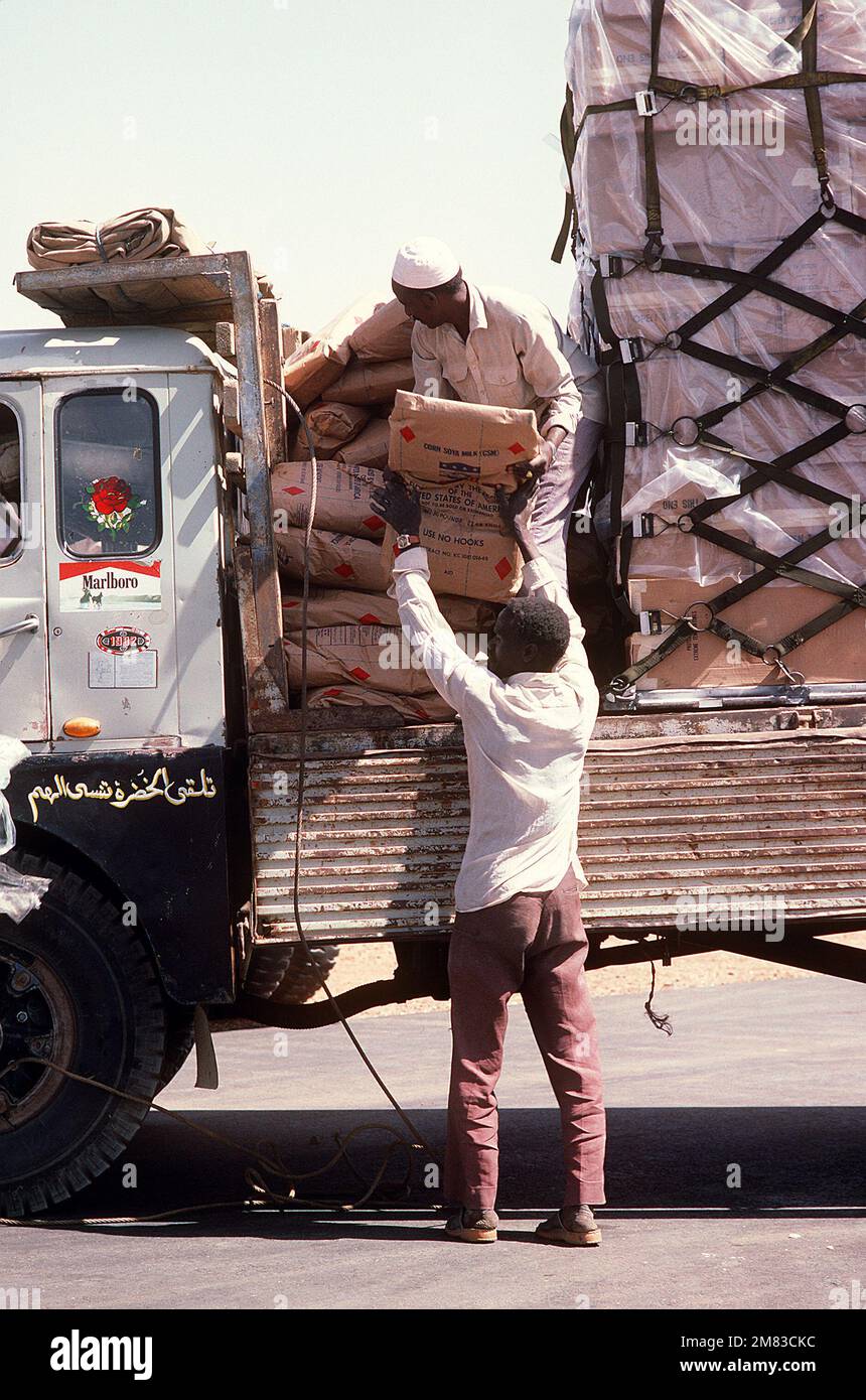Two Sudanese workers load a truck with food and supplies that were flown into the airport aboard a 6th Military Airlift Squadron aircraft during Ethiopian relief operations. The supplies will be moved to a distribution center and given to the needy. Base: Khartoum Country: Sudan (SDN) Stock Photo