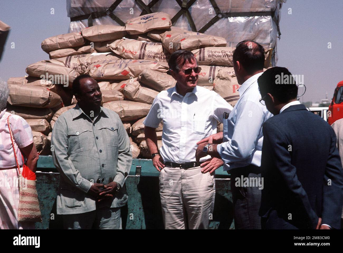 Vice-President George Bush, who was in the Sudan on a fact finding tour, receives a briefing on the Ethiopian relief operation from Dr. Philip Johnston, executive director of CARE. Over 50,000 pounds of food and supplies were delivered to the airport aboard a 6th Military Airlift Squadron aircraft. Base: Khartoum Country: Sudan (SDN) Stock Photo