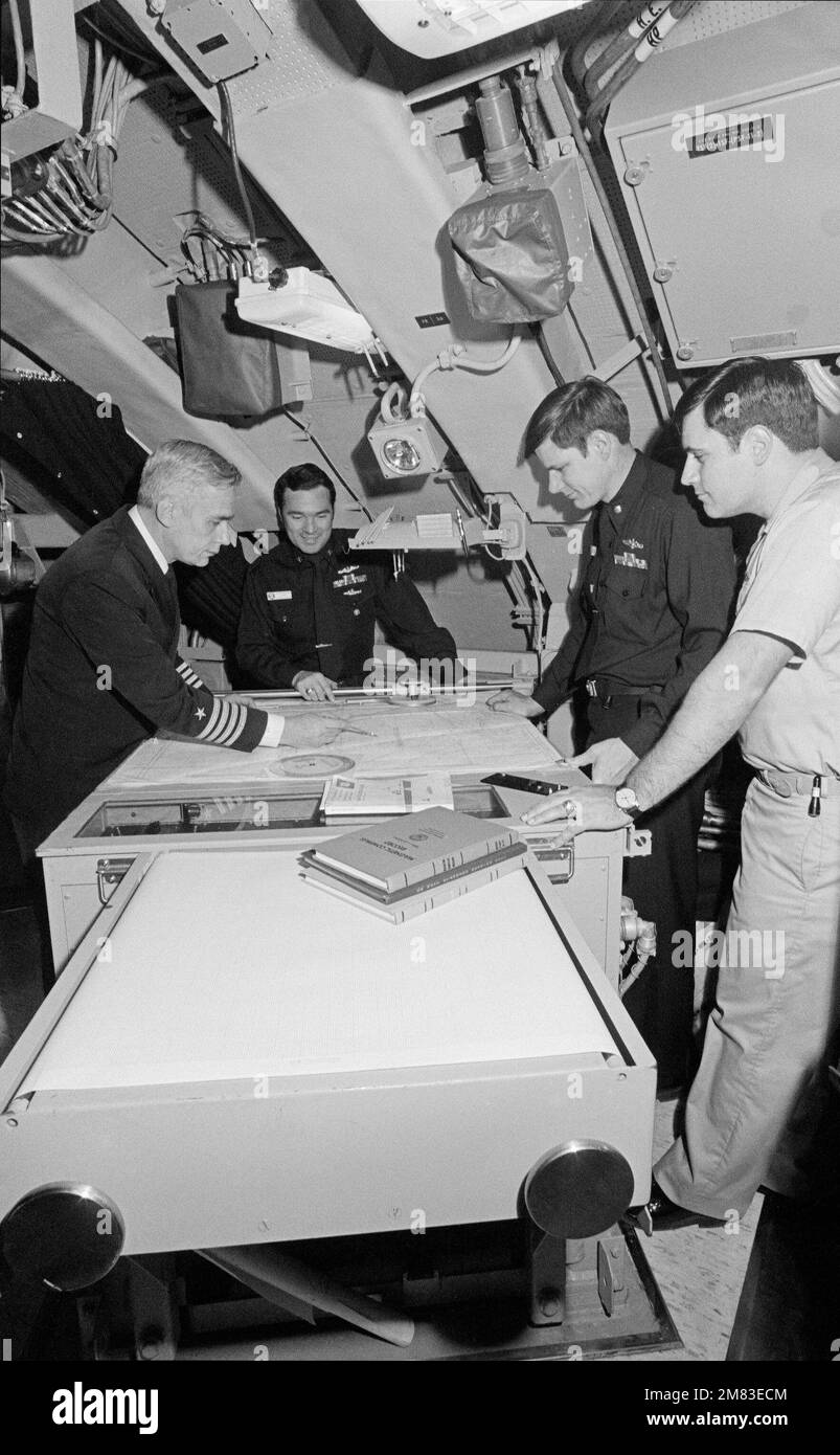 Officers of the nuclear-powered fleet ballistic missile submarine USS GEORGIA (SSBN 729) review a navigational chart on which a future course has been plotted. Left to right, Captain Arland W. Kuester, Commanding Officer (C.O.) blue crew; Captain Myron P. Gray, C.O. gold crew; Lieutenant Commander John H. Sohl III, Executive Officer (E.O.) gold crew; and LCDR Michael G. Duncan, X.O. blue crew. Country: Unknown Stock Photo