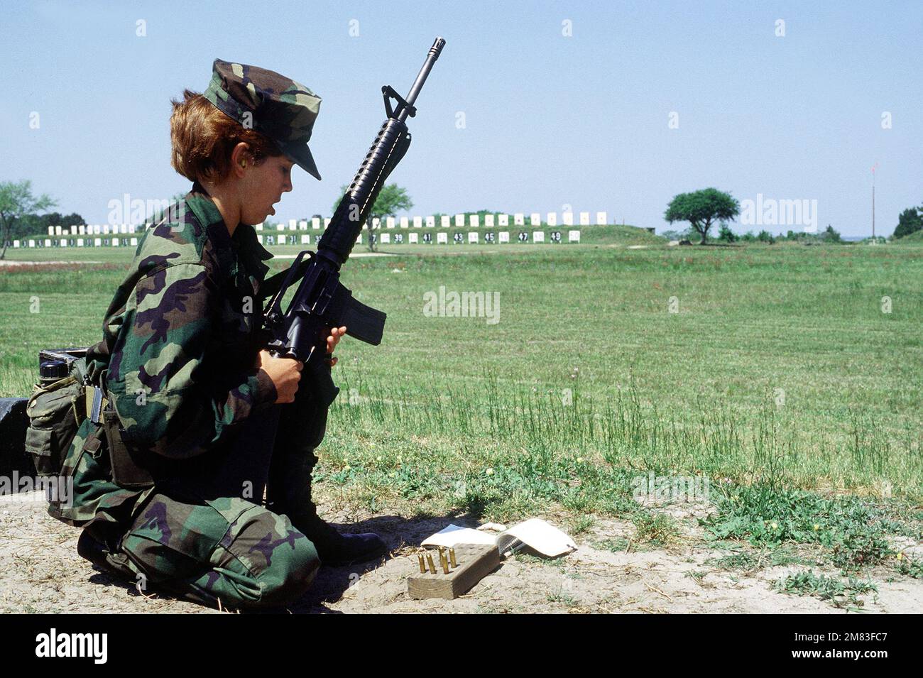 A female Marine recruit prepares to fire an M16A2 rifle from a sitting