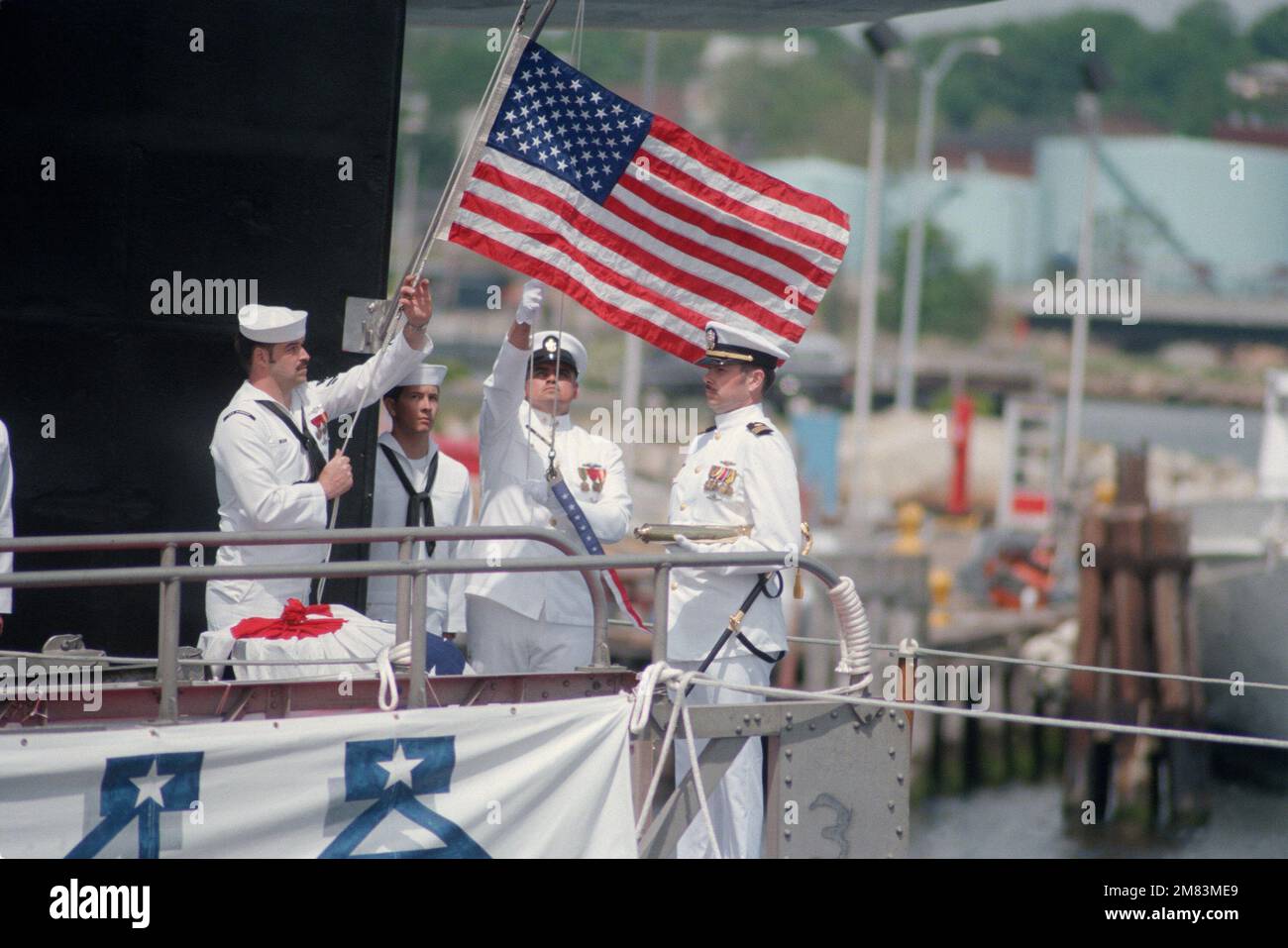 Crewmen rise the colors at the sail of the nuclearpowered strategic