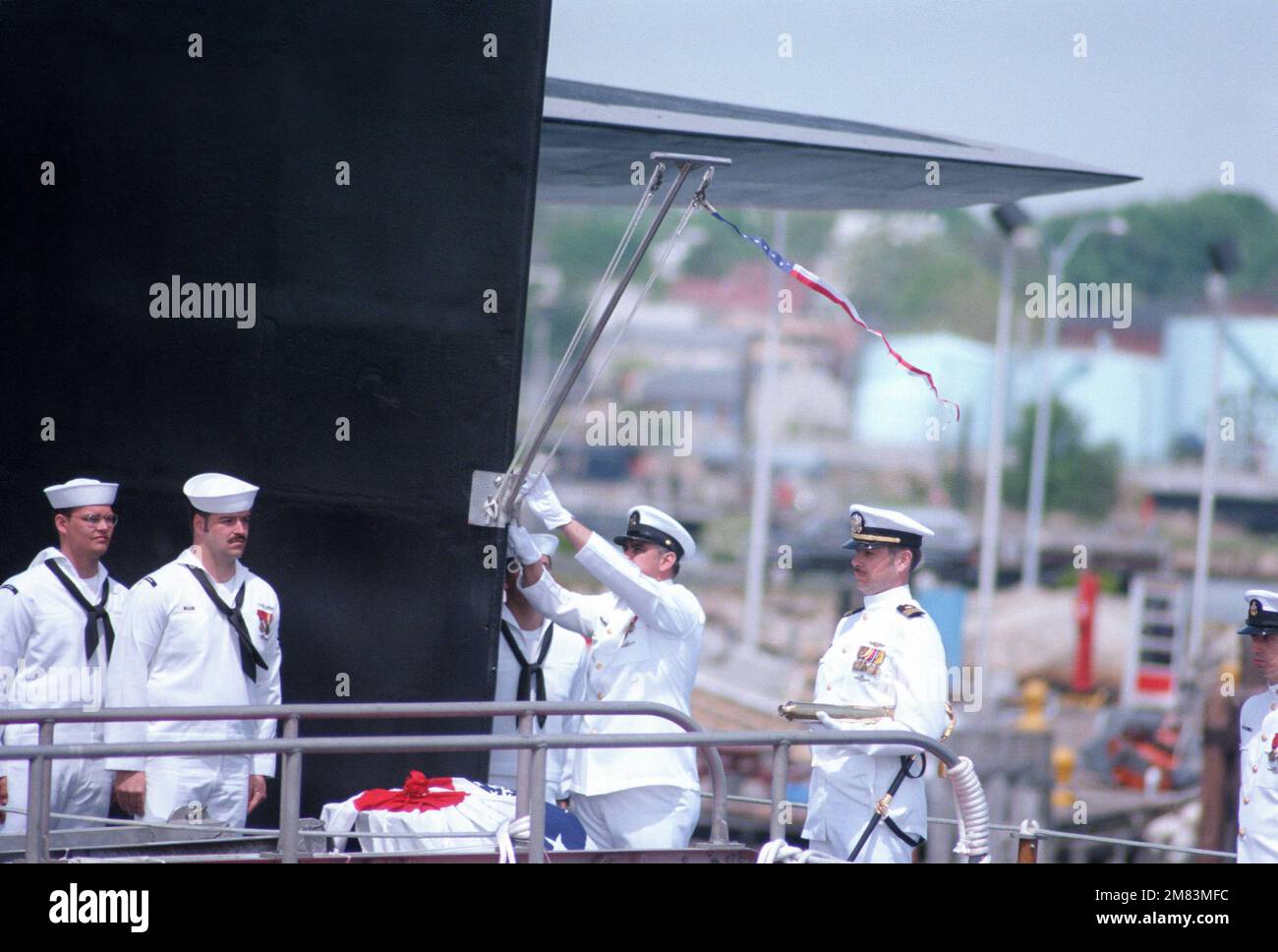 Crewmen raise the commissioning pennant aboard the nuclearpowered
