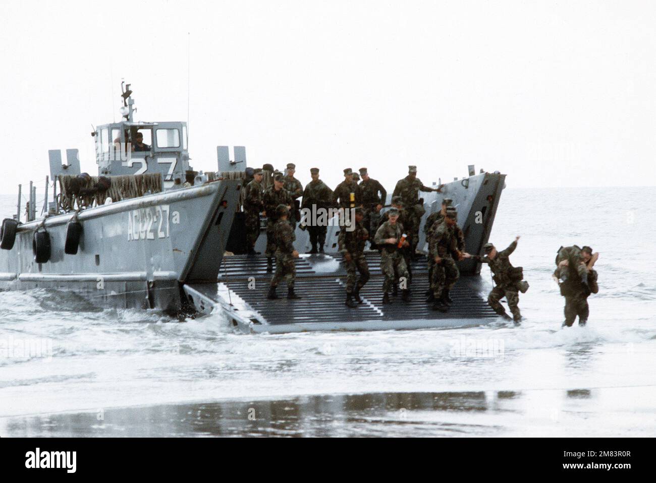 Marines exit from an LCM-8 Mod-1 mechanized landing craft of Assault Craft Unit 2 (ACU-2) at Onslow Beach during Exercise Solid Shield '85. Subject Operation/Series: SOLID SHIELD '85 Base: Marine Corps Base, Camp Lejeune State: North Carolina (NC) Country: United States Of America (USA) Stock Photo