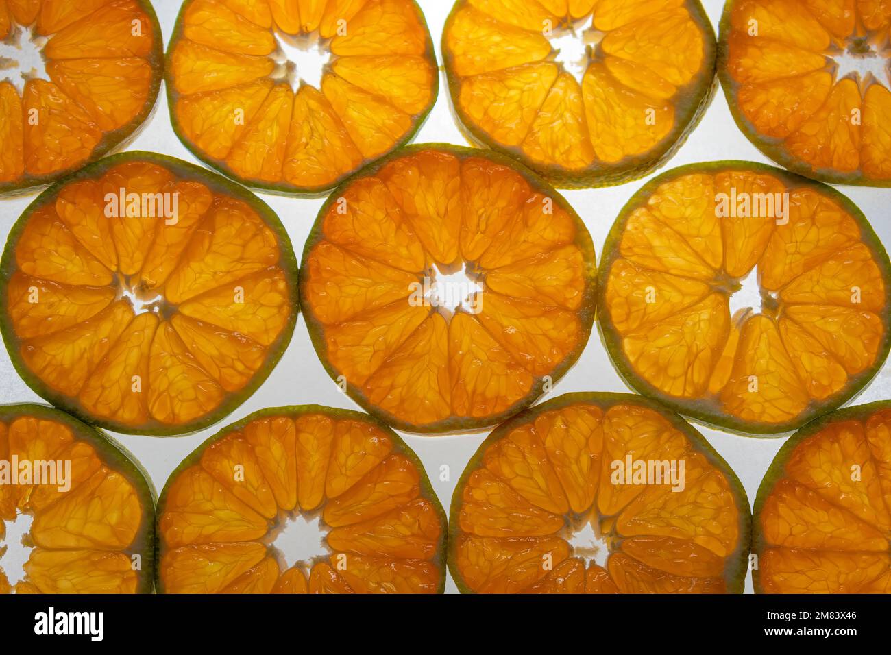 Tangerine slices in backlight. Citrus pattern background. Stock Photo