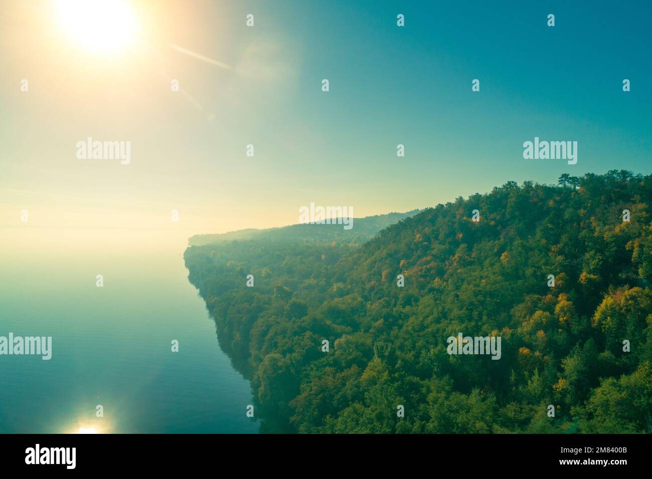 Mountain cape covered with forest on a foggy autumn morning Stock Photo
