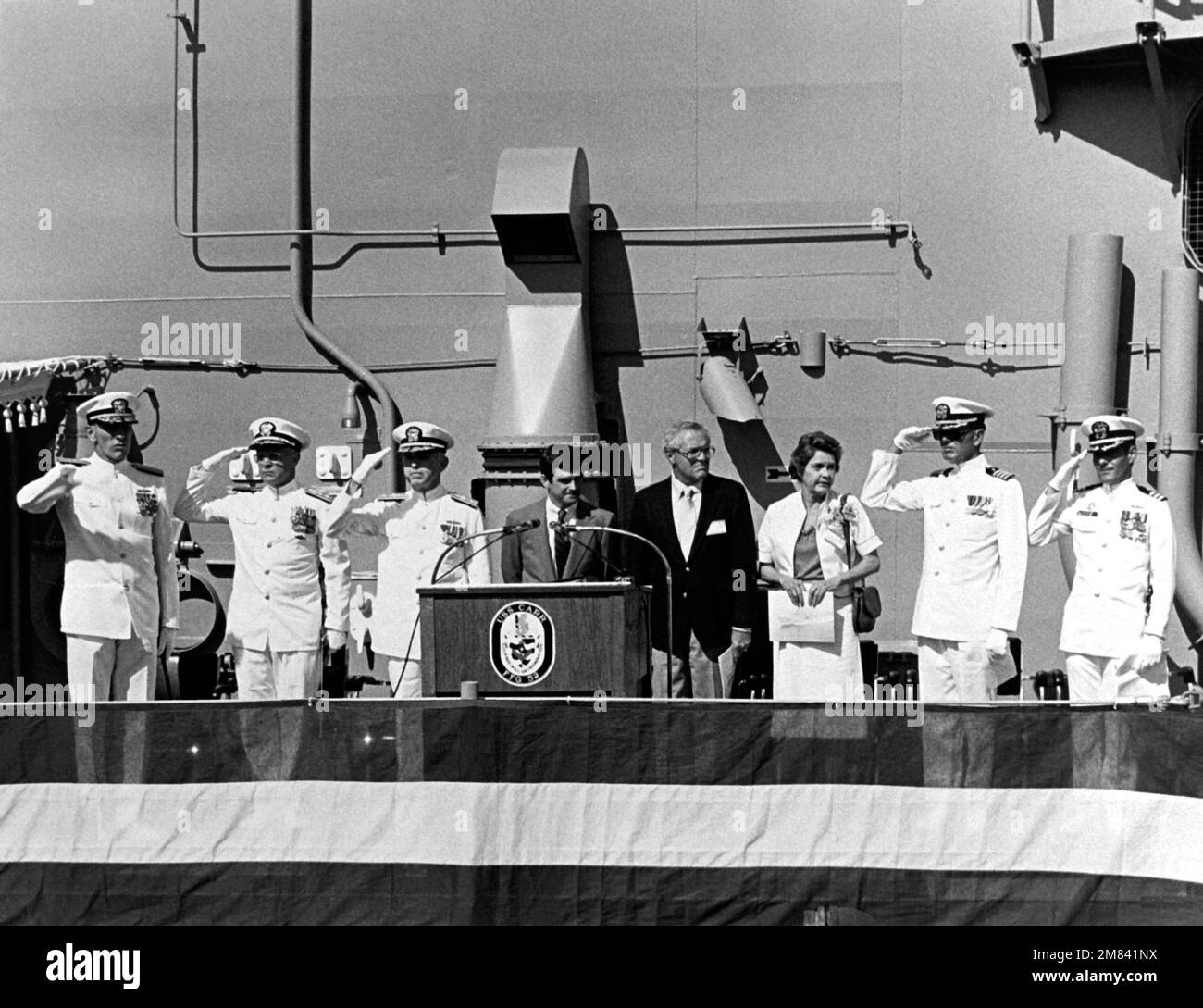 Jack Yusen, SAMUEL B. ROBERTS (DD-413) Survivors Association representative, addresses guests at the commissioning of the guided missile USS CARR (FFG-52). John T. Gilbride Jr, vice president and general manager, Todd Seattle, is seated in the background. Base: Seattle State: Washington (WA) Country: United States Of America (USA) Stock Photo