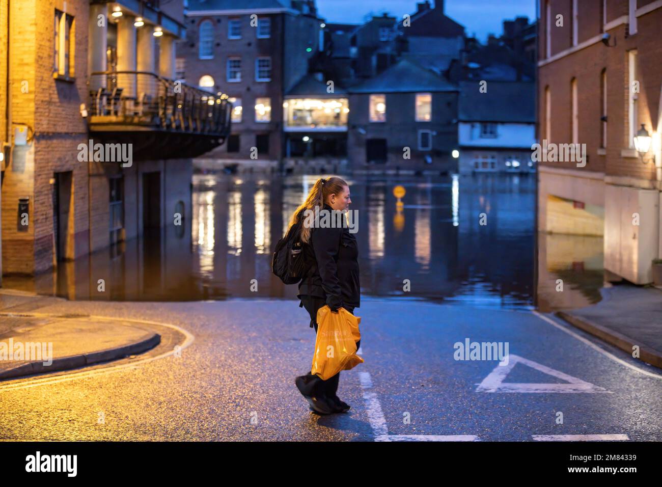 A commuter walks to work passing the flood water as heavy rain causes ...