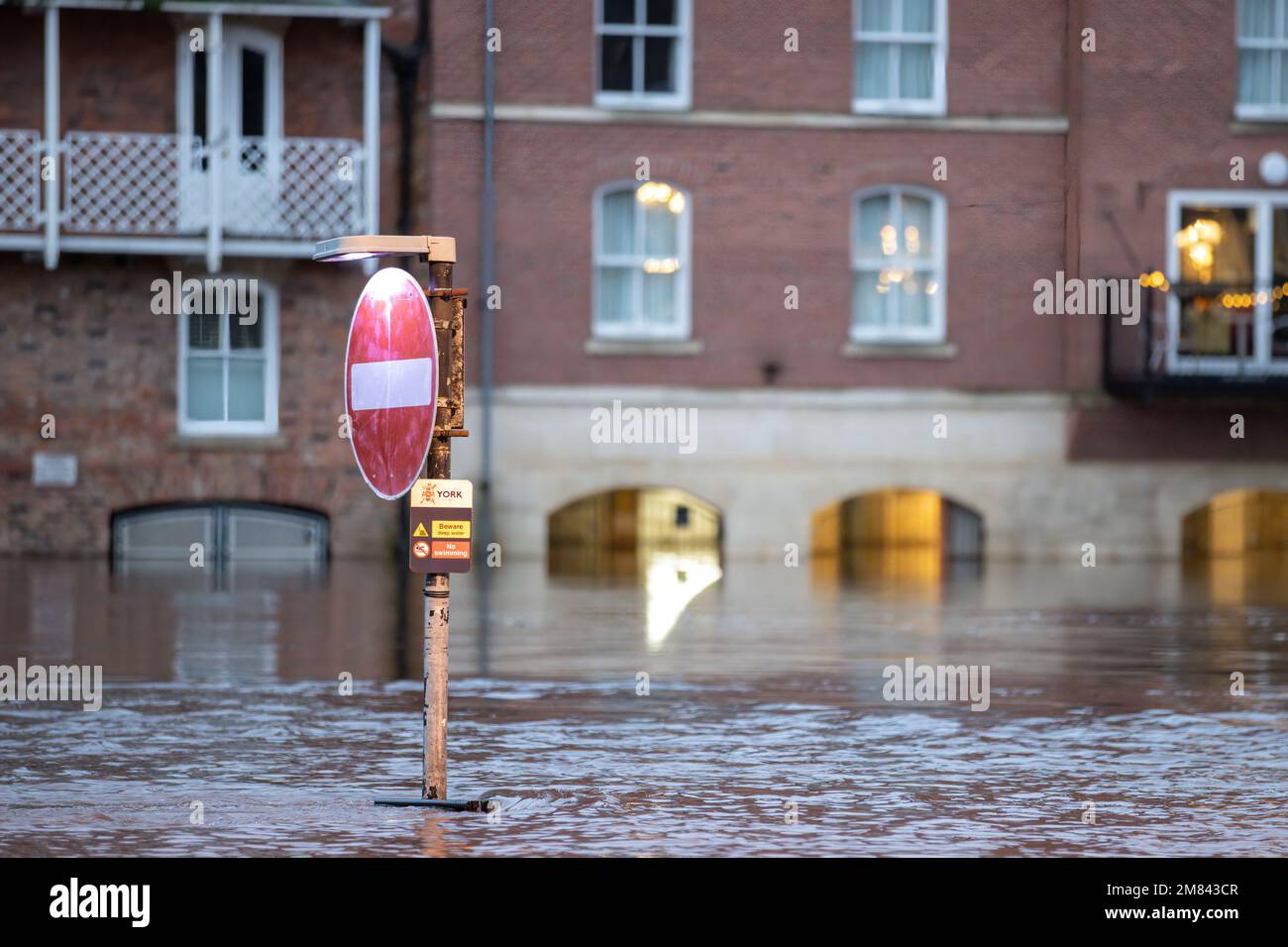 A street traffic sign is submerged in heavy flood water as heavy rain ...
