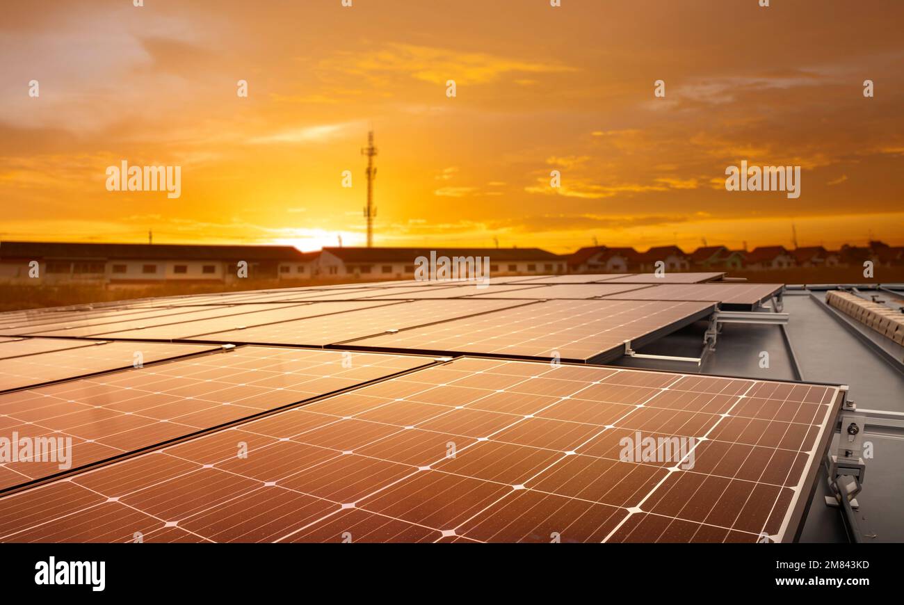 Solar panels on the rooftops of tall buildings reflect the sunset in the city.  Sustainable renewable energy. Modern energy concepts for housing and t Stock Photo