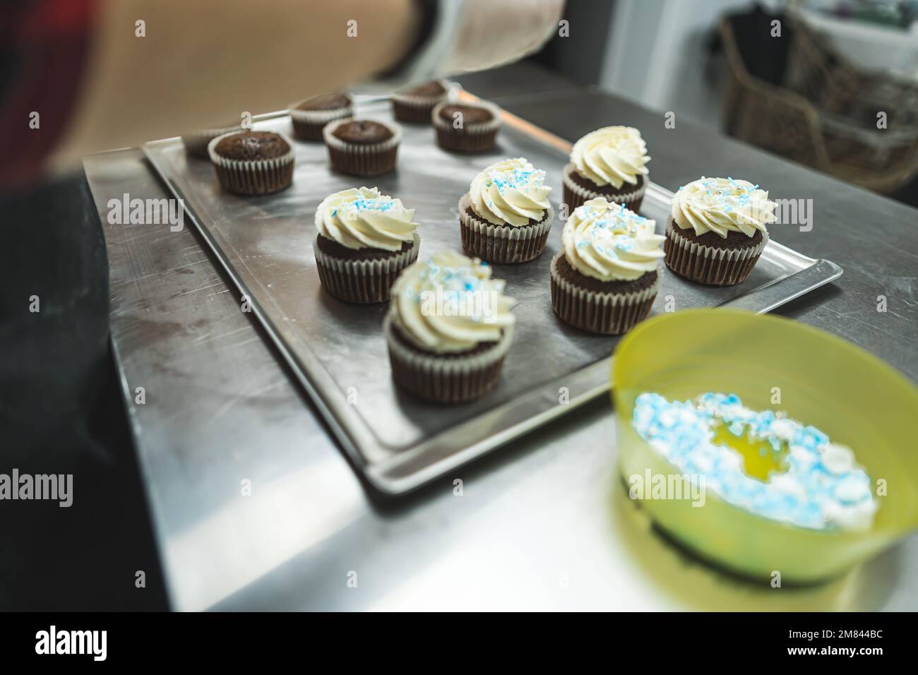 process of decorating chocolate cupcakes with whipped cream and sprinkles, bakery, dessert concept. High quality photo Stock Photo