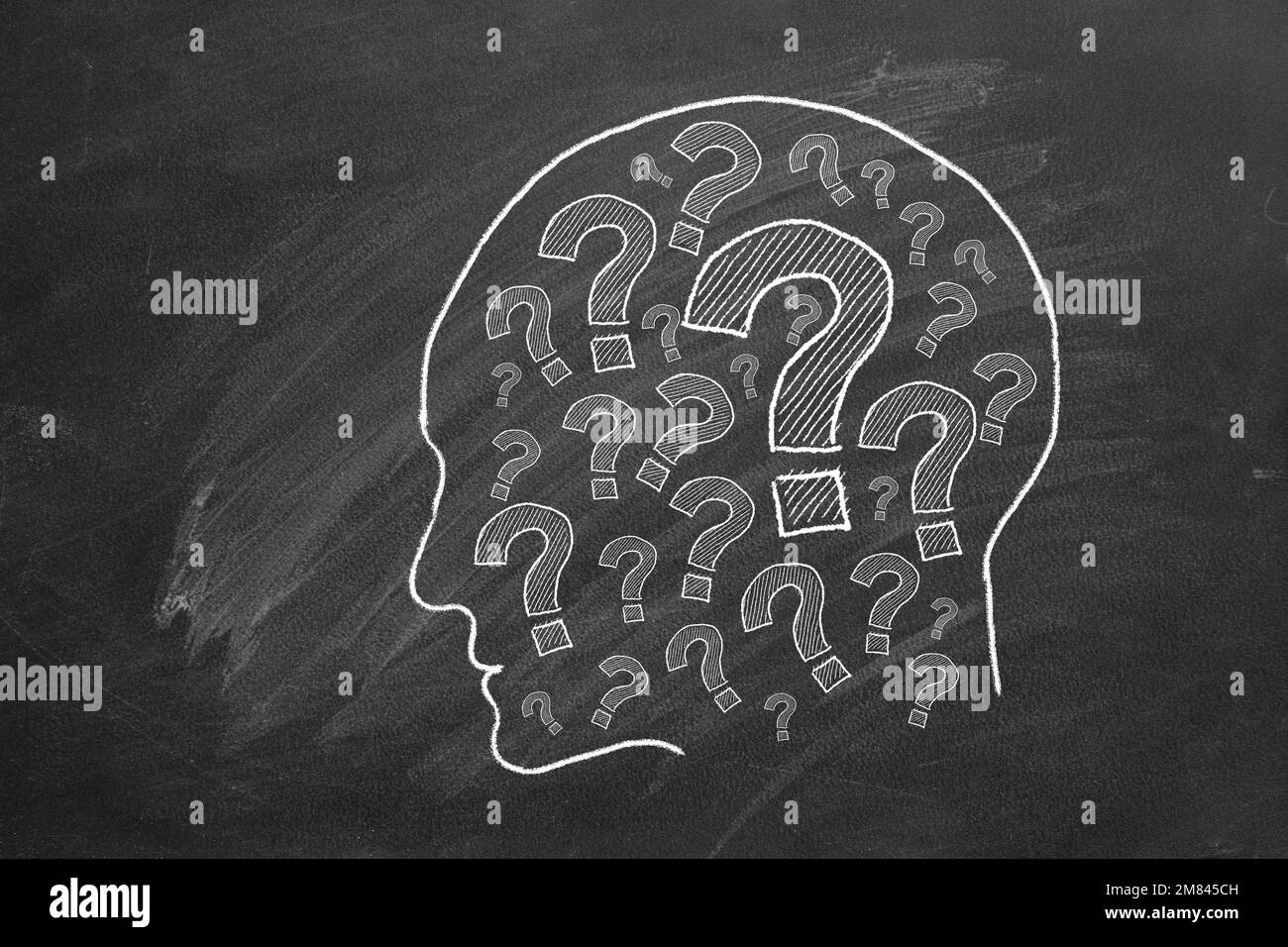 Human head with question marks inside. lustration on blackboard. Stock Photo