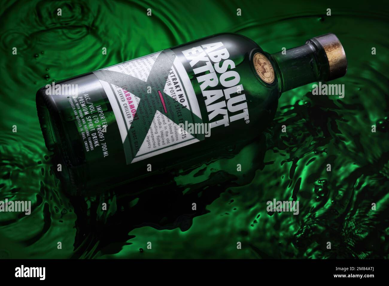 Bottle of Original Absolut Extrakt in water on a green background. Stock Photo