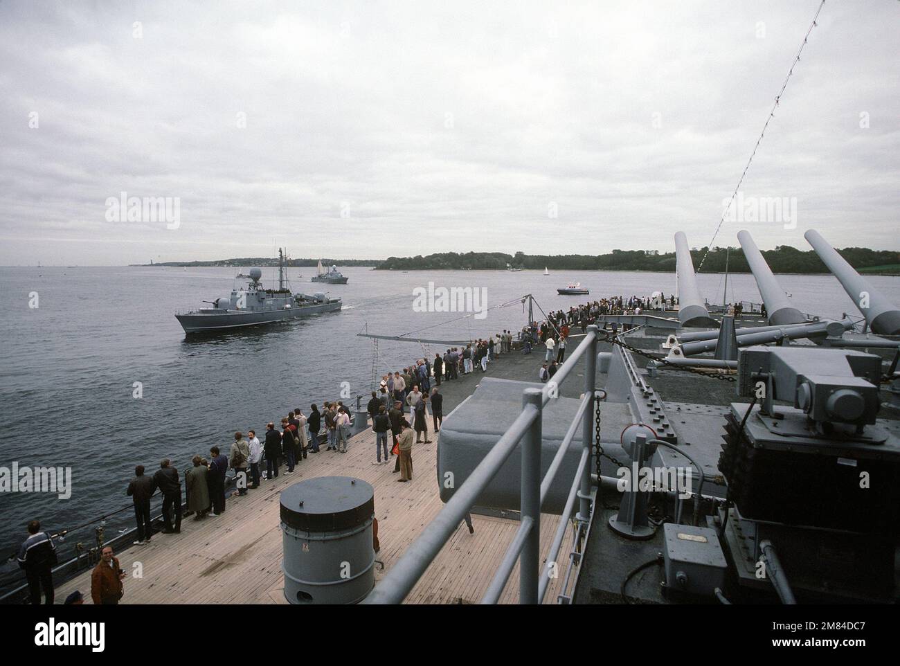 Visitors aboard the USS IOWA (BB-61) watch from the stern as Type 143 fast attack craft missile boats of the West German navy pass in review during the battleship's port visit. Base: Kiel Country: Deutschland / Germany (DEU) Stock Photo