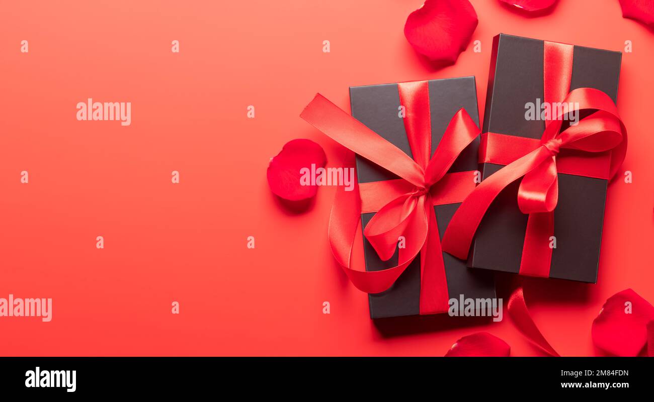 Valentines day card with gift boxes and rose flower petals. On red ...