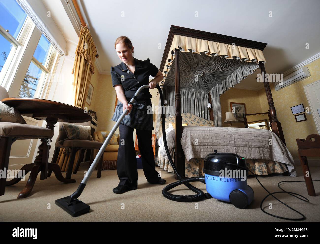 A Housekeeper preparing a hotel room. Stock Photo