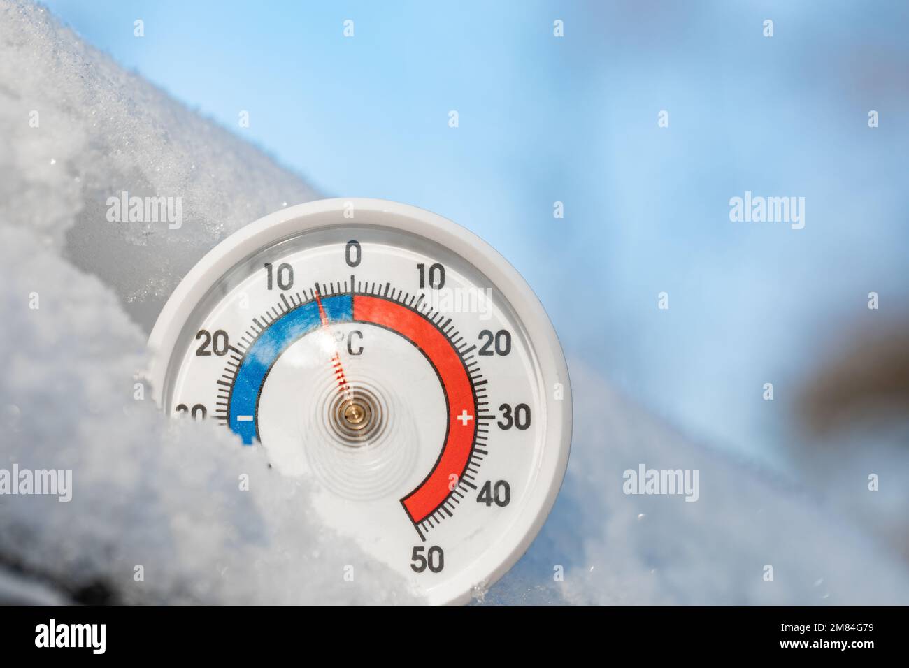 Thermometer with celsius scale in the snow showing minus 4 degree ambient temperature - winter weather concept Stock Photo