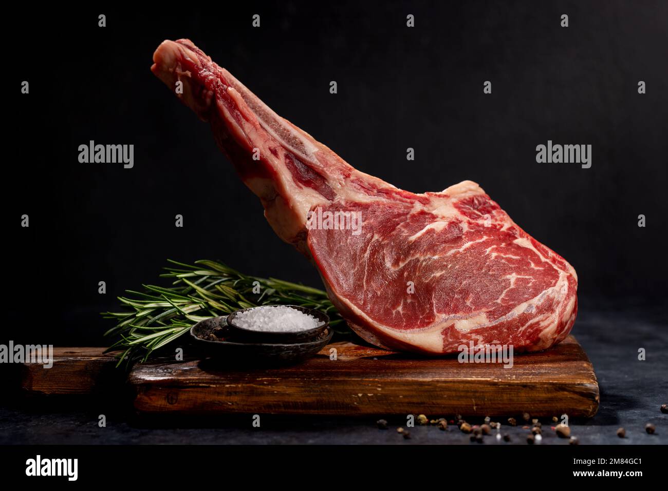 Raw Tomahawk beef steak and spices. Ready for grilling Stock Photo