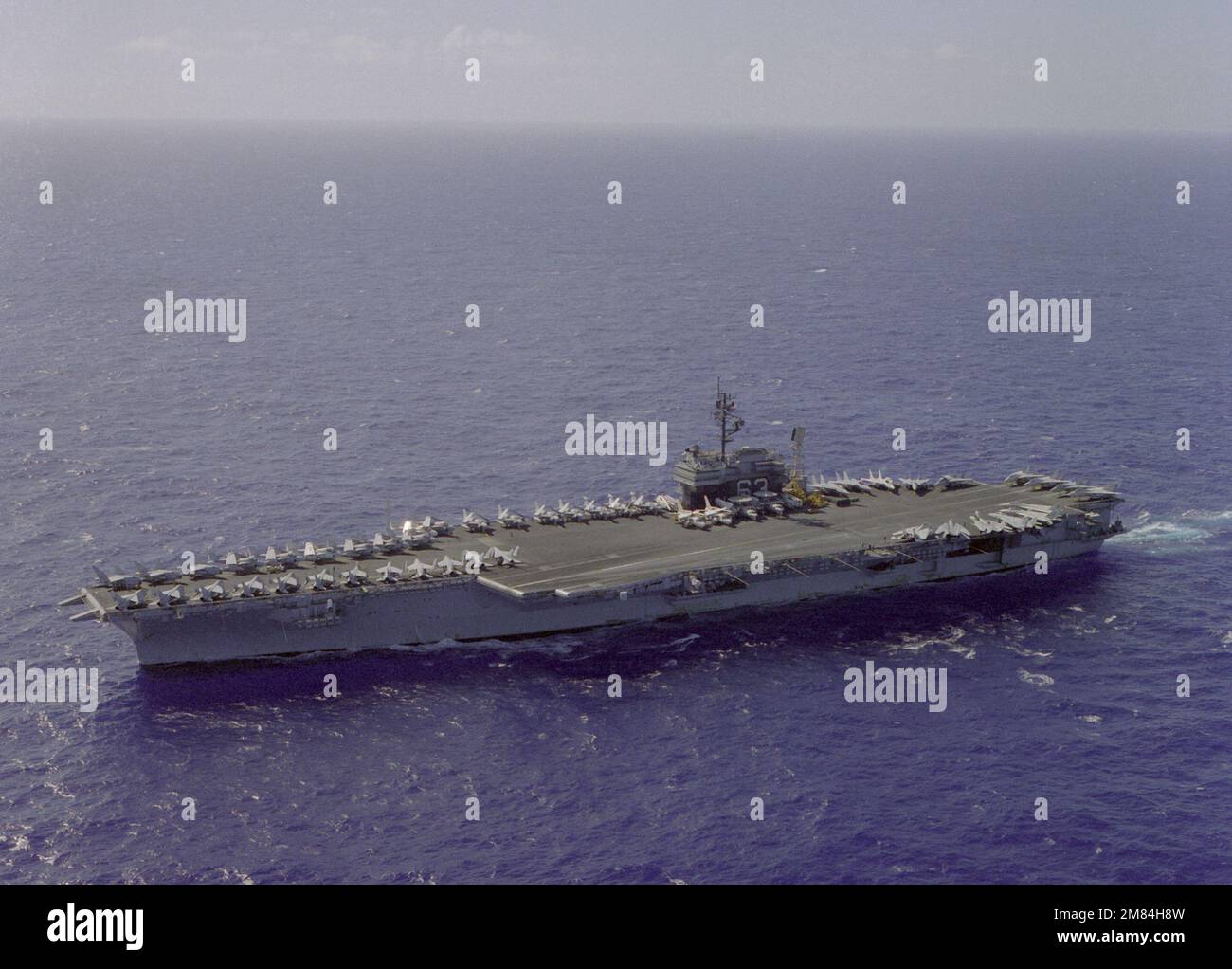 An aerial port bow view of the aircraft carrier USS KITTY HAWK (CV63
